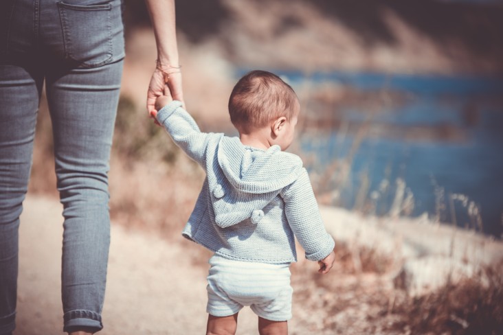 Baby holding hands with parent