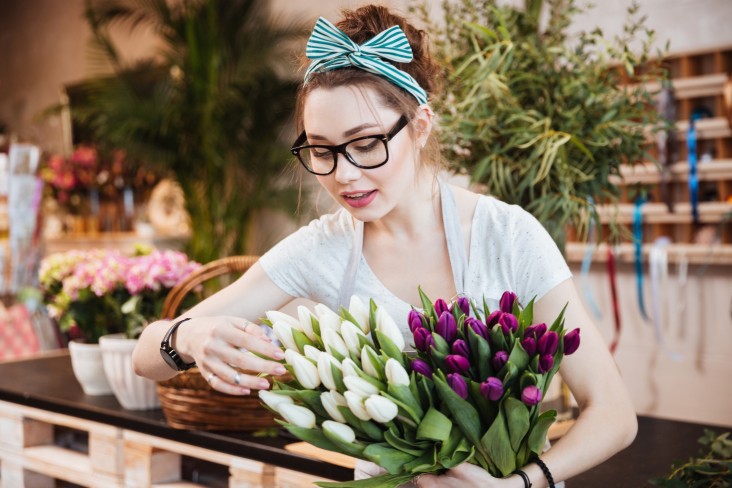 Woman inspects flowers