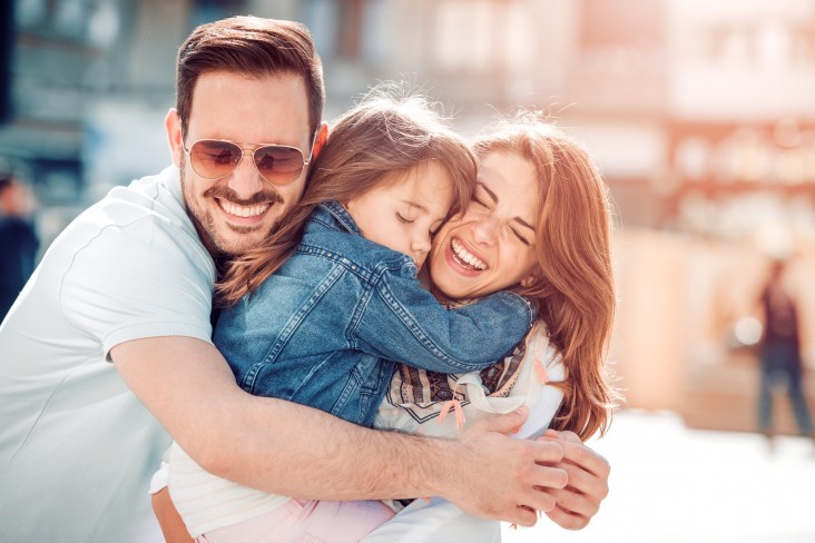 Man and woman hug child