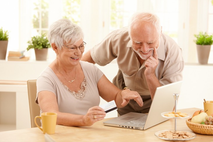 Elderly couple look at laptop