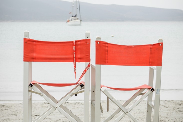 Chairs with a boat in the water 