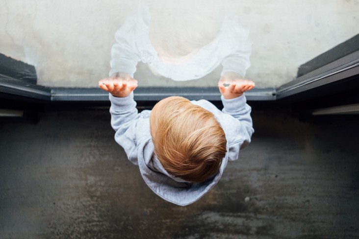 child pressed against window