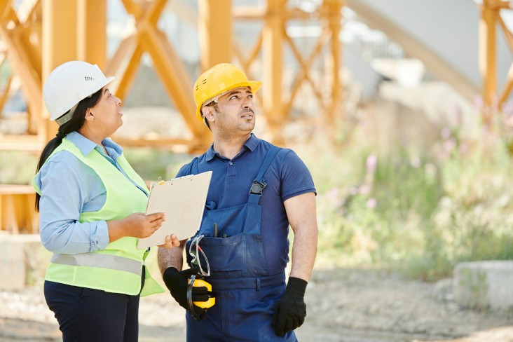 Two people inspecting building site
