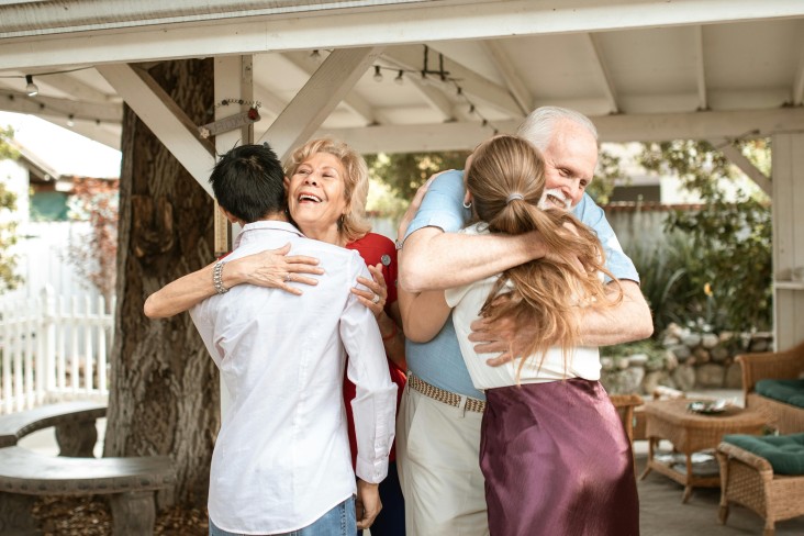 Parents hugging adult children